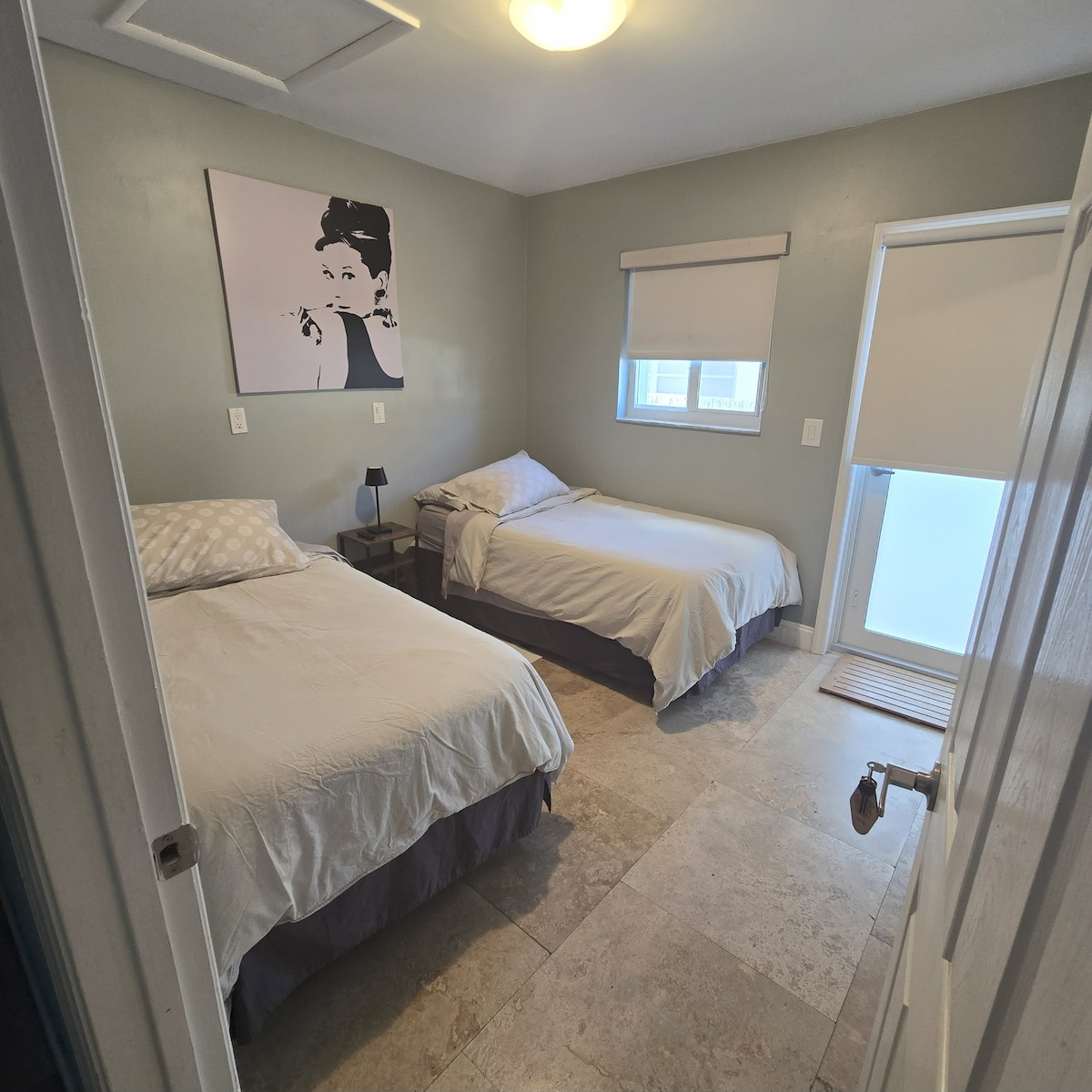 غرفة مريحة بسريرين مع الكثير من الضوء الطبيعي - ولكن أيضًا مع ستائر داكنة