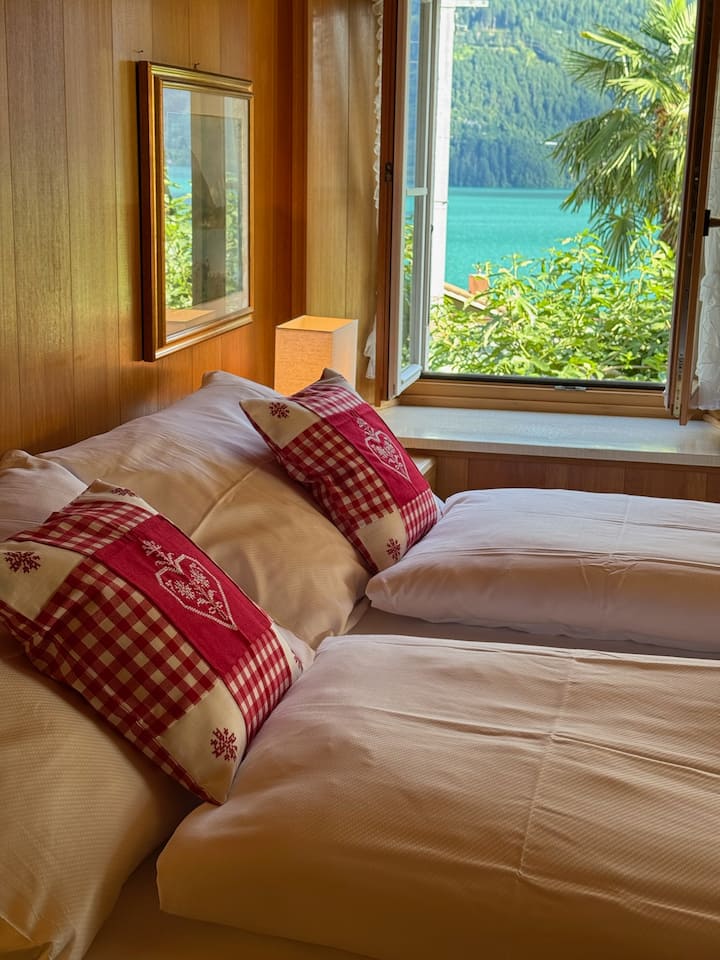 Chambre alpine traditionnelle avec vue sereine sur le lac et la montagne
