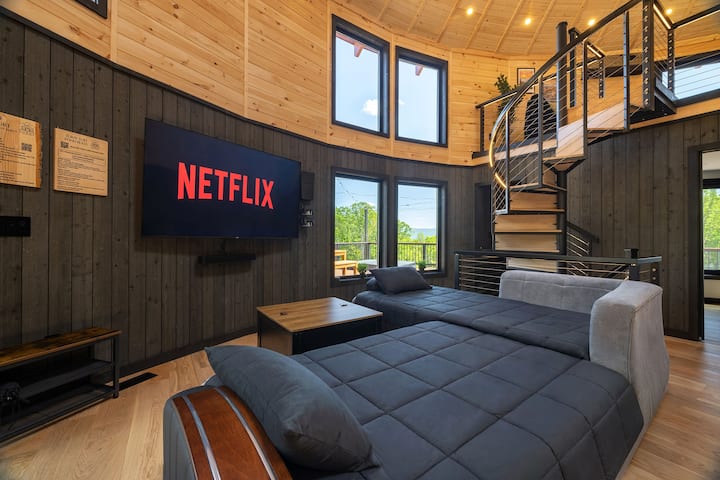 Sofa beds make this bright lounge a flexible space for movie nights or extra guests, with big windows to the deck and easy access to the loft above.