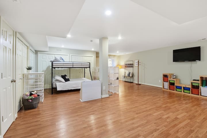 Vista del dormitorio grande/habitación abierta que tenía un rincón de litera con una cama doble sobre la cama completa que es perfecta para niños o invitados adicionales. A la derecha hay un televisor sobre un brazo ajustable y una variedad de equipos de entrenamiento.