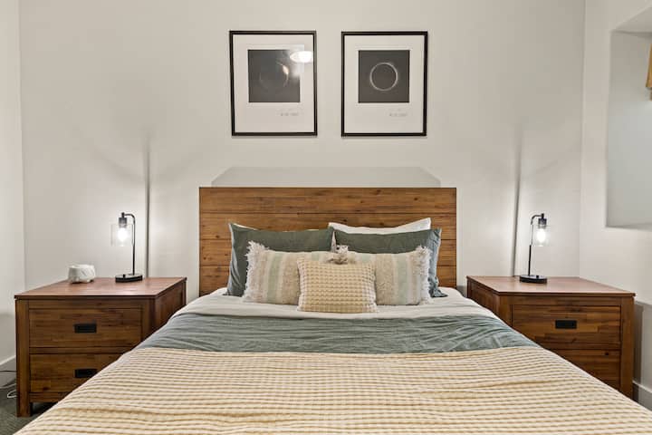 เตียงขนาดควีนไซส์ที่อบอุ่นพร้อมหมอนนุ่มและการตกแต่งที่เน้นเนื้อสัมผัสเพื่อการนอนหลับพักผ่อนยามค่ำคืน