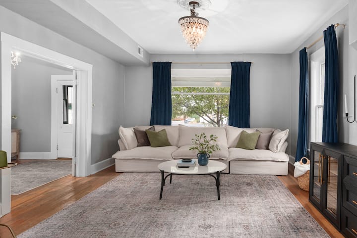 Მზით გაჟღენთილი მისაღები ოთახი პლუშის კრემისფერი დივნით - იდეალური ადგილი დენვერის დათვალიერების შემდეგ დასასვენებლად და დასატენად.