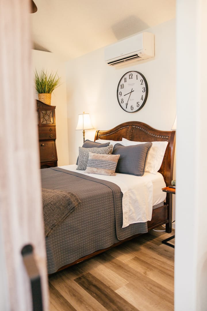 Peaceful bedroom featuring a comfortable queen bed with plush linens, bedside lamps, and vaulted ceilings. A quiet, cozy retreat designed for restful nights after a day enjoying the ranch.