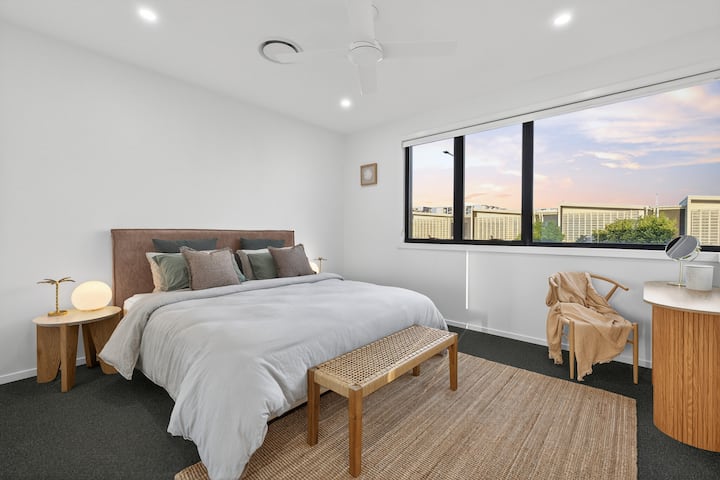 Master bedroom featuring a luxurious king size bed, enquite with oversized tub, ducted air conditioning and ceiling fan and the most AMAZING natural light streaming in!