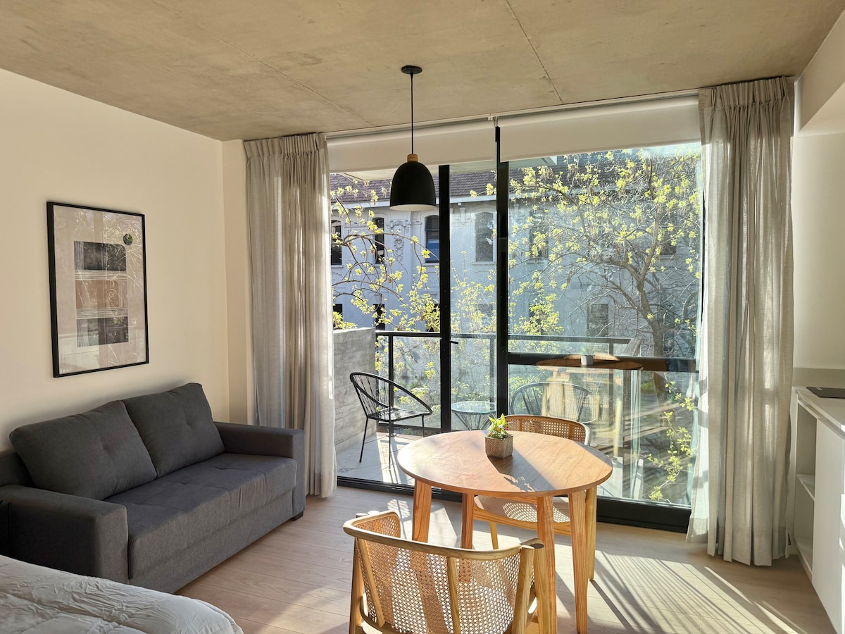 Photo 1 is the strongest representative interior: it clearly shows a bright, appealing living/dining area with sofa, table, and balcony doors, giving travelers a good sense of the unit layout and feel. It’s spacious, well-lit, and more room