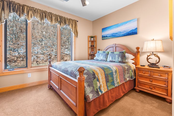 This serene guest bedroom offers a cozy escape with mountain-inspired decor, a comfortable bed, and peaceful views that make it easy to unwind and recharge.