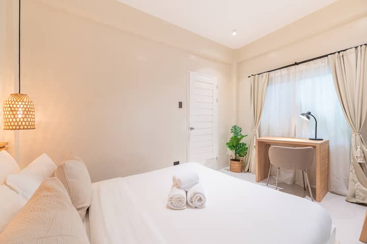 Nuestro segundo dormitorio con cama tamaño queen y escritorio de trabajo con lámpara. 