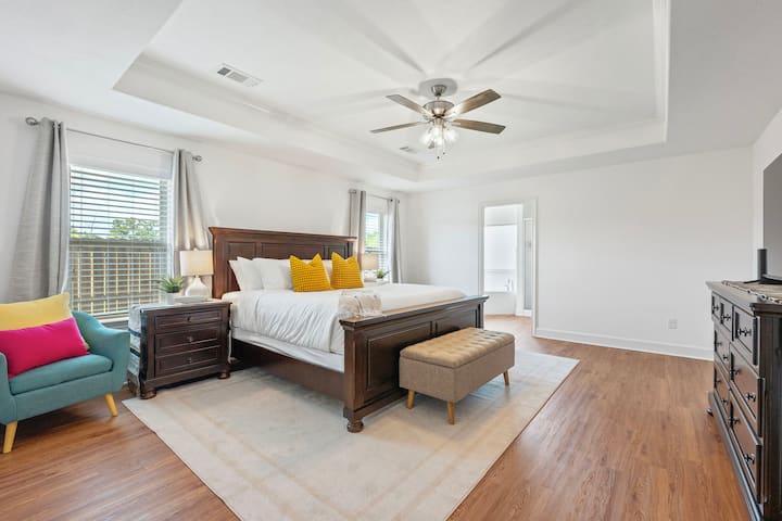 חדר שינה ראשי – להירגע בנוחות עם מיטת קינג סייז, טלוויזיה חכמה של פיליפס בגודל 50 אינץ', עיצוב מסוגנן ושפע של מקום ללילות מרגיעים אחרי ימי משחקים או מפגשי משפחה.