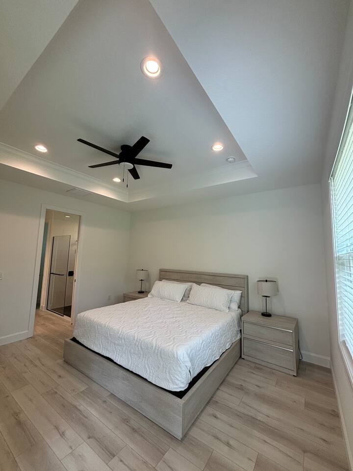 Pohodlná posteľ s matracom veľkosti King a stropný ventilátor