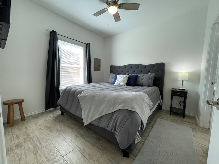 Dormitorio 1 con cama tamaño king y televisor inteligente, baño privado y vestidor.
