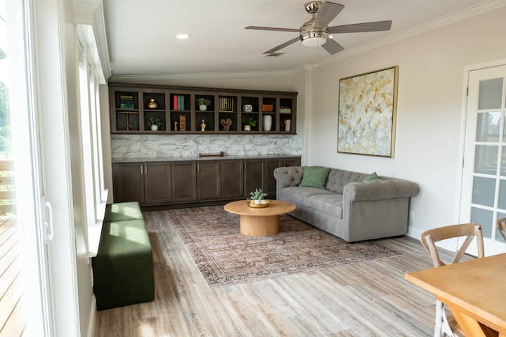 חדר המשחקים של בית האחו עם ספה נפתחת זוגית ובר רטוב. משחקי קופסה, משחק חור תירס ומשחק Connect Four בגודל טבעי. דלתות הזזה מזכוכית למרפסת החיצונית.