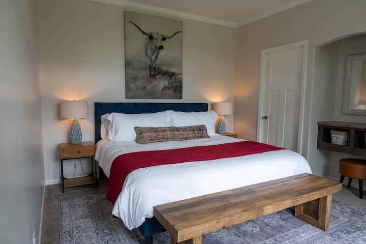 חדר השינה הראשי של גרוב האוס עם חדר ארונות וחדר רחצה צמוד.