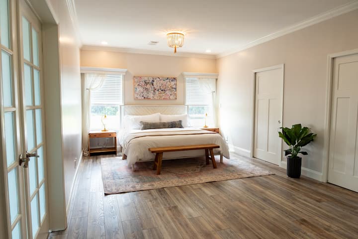 חדר השינה הראשי של בית האחו עם שני ארונות בגדים, חדר רחצה צמוד וטלוויזיה.