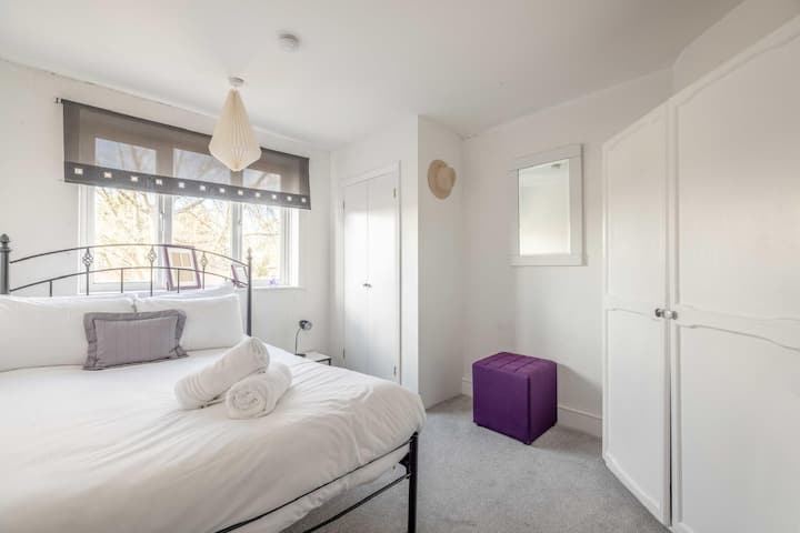 Bedroom Retreat: Modern furnishings, airy vibe, and warm wood floors for a delightful stay!