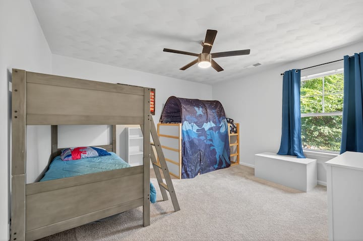 Spálňa s poschodovými posteľami v plnej veľkosti a dostatočným úložným priestorom, ideálna pre skupiny alebo rodiny.