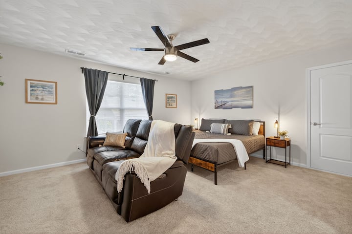 Priestranná spálňa s dvoma posteľami, útulnou posteľnou bielizňou a veľkými oknami na prirodzené svetlo.