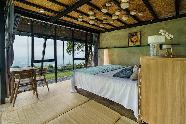 Útulná spálňa s priestrannou manželskou posteľou, veľkými oknami na prirodzené svetlo a teplým dreveným dizajnom stropu. Vhodné až pre 3 hostí, ideálne na oddychový pobyt s výhľadom do záhrady.