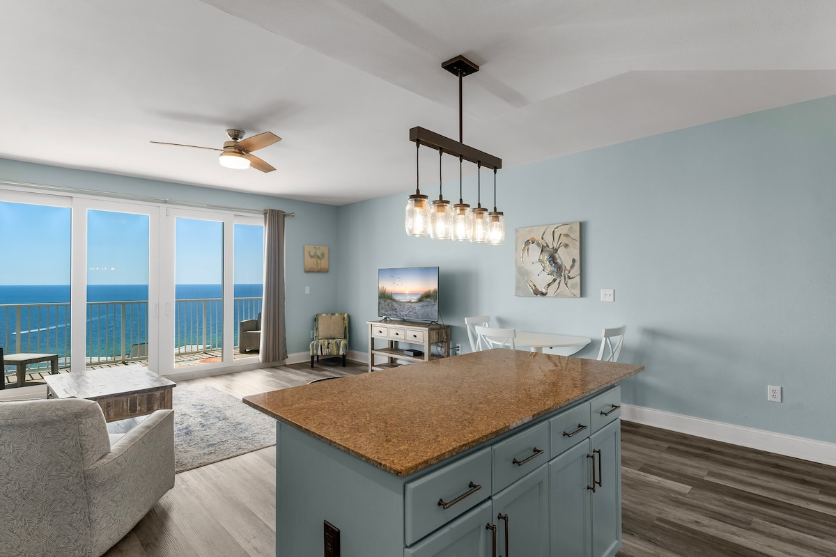 Des fenêtres du sol au plafond encadrent des eaux émeraude à perte de vue.