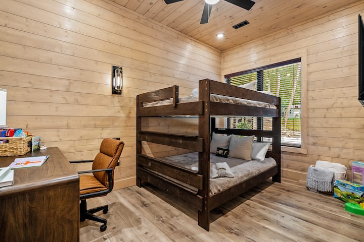 Bunk bedroom perfect for kids or friends, complete with cozy touches and workspace.