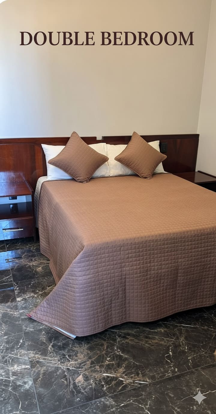 Cama doble, baño privado que da a un pequeño patio con vistas a la zona de la piscina