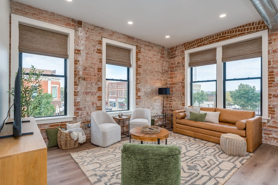 Living room with queen sofa bed and exposed brick in a New Ulm loft