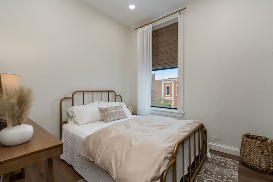 Queen bedroom with room-darkening shades in a historic downtown New Ulm loft