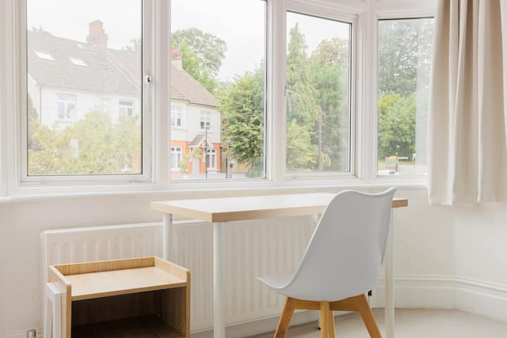 غرفة النوم 1: ملاذ واسع في الطابق الأول مع سرير بحجم كينج ومساحة عمل مخصصة ورف ملابس وحوض غسيل - يجمع بين الراحة والعملية.