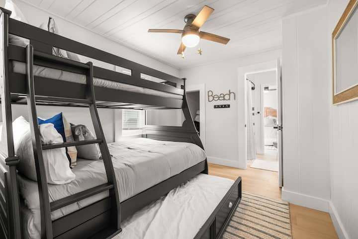 Poschodová posteľ s manželskou posteľou na vrchu a výsuvnou kolieskovou postieľkou. Pripojená kúpeľňa Jack a Jill.