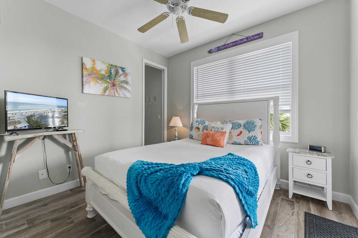 חדר שינה קווין סייז למעלה עם טלוויזיה, חדר הלבשה, מרפסת עם נוף חלקי למפרץ. 