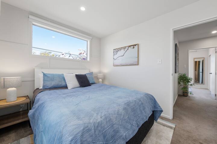 استرخ في غرفة النوم المصممة على طراز الشاطئ مع سرير مريح بحجم كوين ومصابيح قراءة بجانب السرير وخزانة واسعة مع علاقات. موجود بجوار الحمام بشكل ملائم لسهولة الوصول والراحة القصوى.