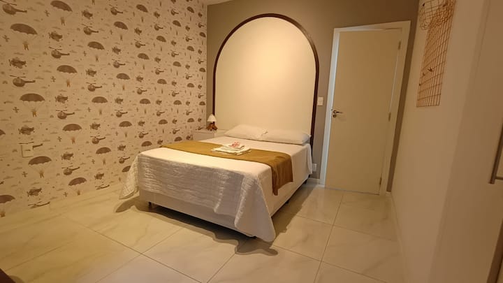 Quarto amplo com cama de casal e ar condicionado.