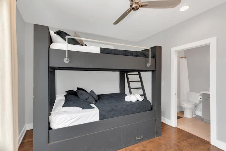 Spacious bunk room with twin-over-full beds, smart TV, ceiling fan, and natural light. Comfortable setup with modern finishes—perfect for kids, friends, or extra guests needing a flexible sleeping space.