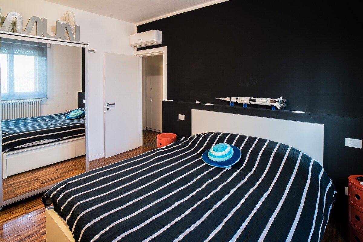 双人卧室，配备带大镜子的衣柜和分体式空调。