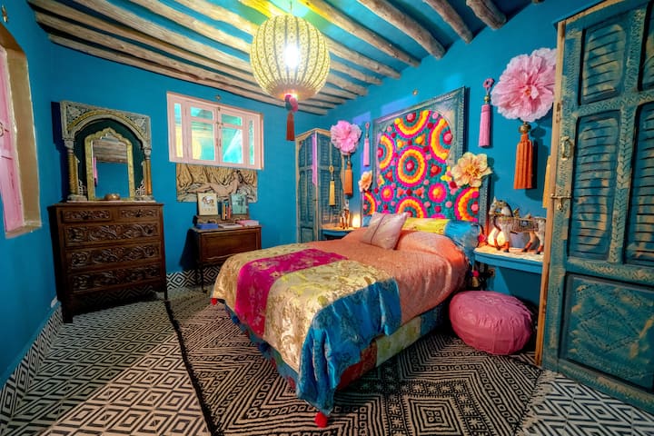 On the first level of our two-story rooftop, this colorful room opens to the sky. Pom-poms, tassels, and a mini library add playful charm, with two closet spaces for comfort. Throw open the doors and watch the light shift above in the Marrakech sky.
