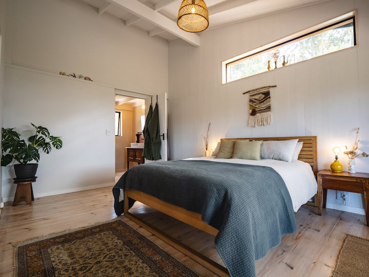 Spavaća soba s bračnim krevetom (160 – 179 cm), poplunom od perja i posteljinom od 100 % lana. Preklopna vrata vode na terasu.