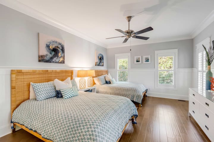 This main floor bedroom has two queen beds with a TV. It has a private toilet and sink and then shares a shower with bedroom 5.