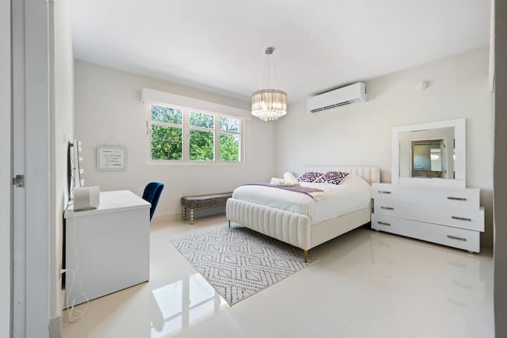 Habitación luminosa y acogedora con cama tamaño queen, baño moderno y grandes ventanales que llenan el espacio de luz natural. Diseñada para la comodidad y la relajación con acabados elegantes y una decoración serena