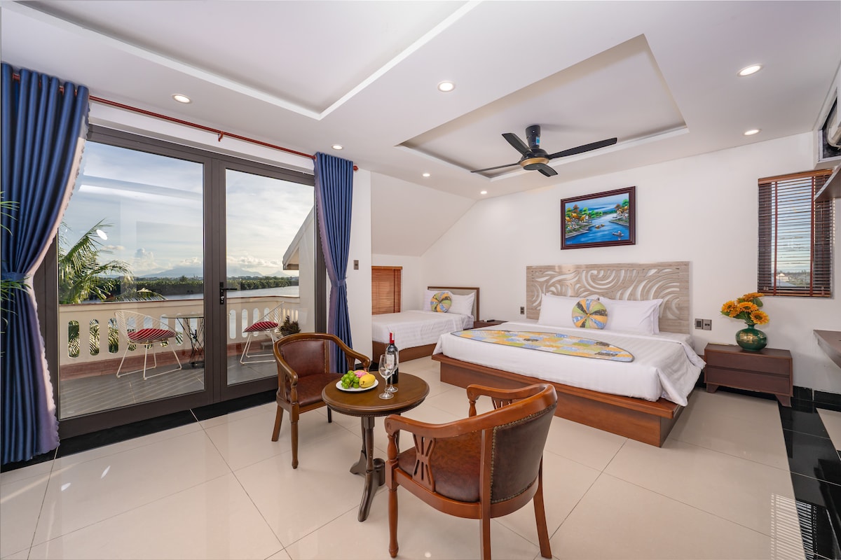 ห้องนอนกว้างขวางและสว่างไสว มีเตียง 2 เตียงและระเบียงที่มองเห็นแม่น้ำ 