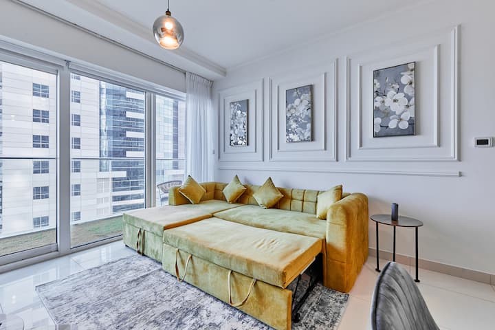 Elegantan dnevni boravak s udobnim kaučem na razvlačenje, elegantnim uređenjem, pametnim televizorom i izlazom na balkon s pogledom na more, Palm Jumeirah i Atlantis