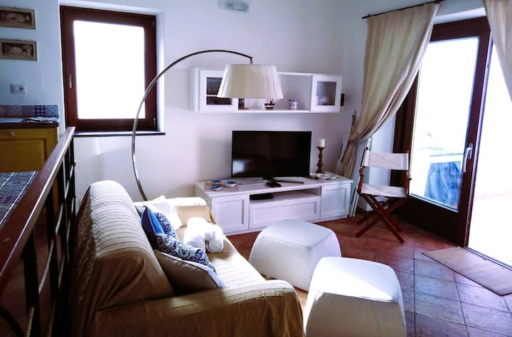 coin salon/télévision et porte-fenêtre donnant sur la terrasse