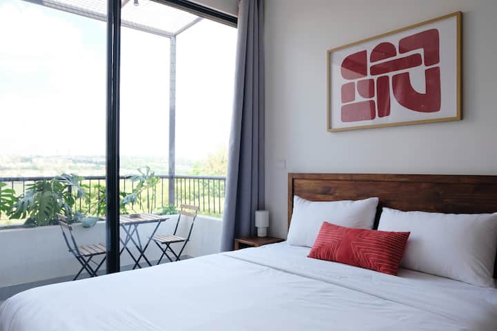 Cama tamaño queen con sábanas suaves. Durante el día tendrás luz brillante en la habitación desde las grandes ventanas, y por la noche puedes usar las cortinas opacas y las luces nocturnas para crear un ambiente relajante para dormir. 
