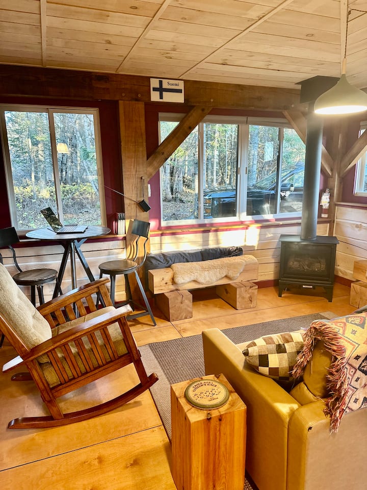 Udoban prostor za sjedenje okružen prozorima.  Gledajte snijeg, izlazak sunca ili divlje životinje dok sjedite pored plinskog kamina.