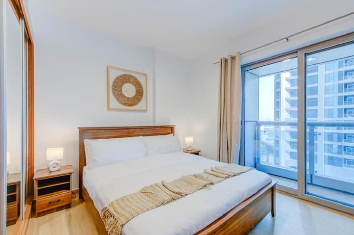 Chumba cha 2 cha kulala: 

Chumba cha pili cha kulala kilicho na kitanda aina ya walnut, roshani ya kujitegemea iliyo na mwonekano wa bwawa, meza mbili za pembeni zilizo na taa, kabati lenye kioo, mchoro wa boho, mkimbiaji mweupe na wa njano wa kitanda, mwanga wa asili na vivuli vinavyofanya chumba kiwe na giza.