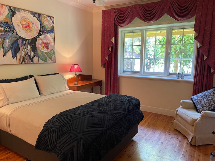 Glavna spavaća soba u ovoj lijepoj kući iz povijesnog razdoblja vrlo je prostrana, ima visoke stropove i veliki prozor s pogledom na drvo murve.