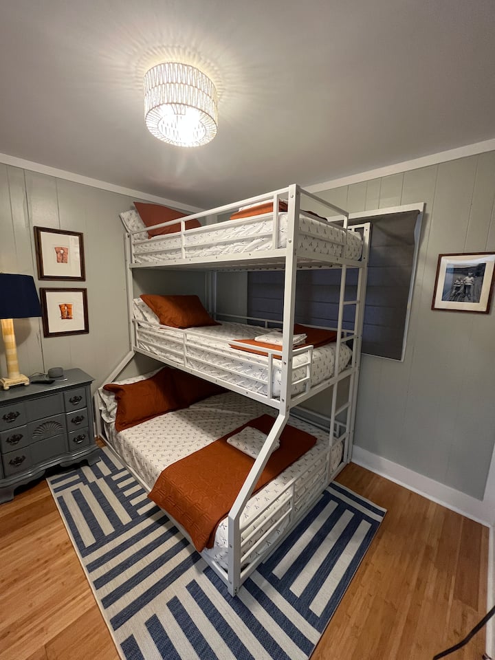 Kitanda cha ghorofa tatu (kitanda cha mapacha juu ya kitanda cha mapacha juu ya kitanda kamili) kinatosha watu 4. Televisheni pia imewekwa kwenye ukuta wa pembeni.