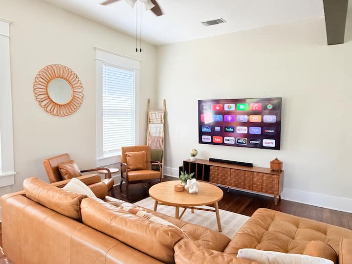 Relax and recharge in this inviting living area with an Article leather sectional, 2 accent chairs, spacious layout, and smart TV for easy entertainment.