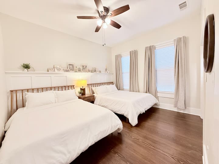 This homey bedroom offers two stylish queen beds, large windows with blackout curtains, and a clean, modern design for a restful stay.