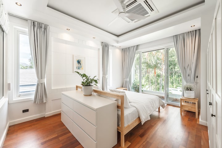 غرفة نوم بحجم كينج في الطابق الثاني، تطل على المساحات الخضراء المورقة وحمام السباحة ولها شرفة خاصة بها وحمام مع دش ومرحاض وحوضي غسيل. 