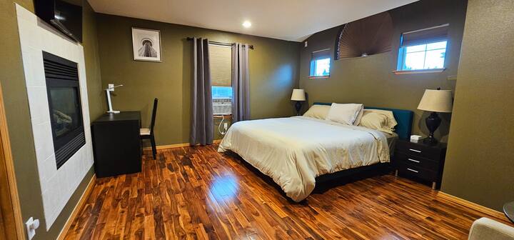 Prostrana glavna spavaća soba s bračnim krevetom i romantičnim prozirnim kaminom.