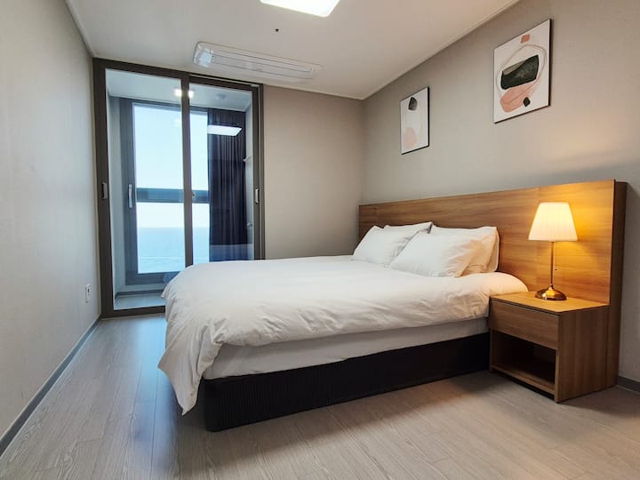 Природна светлина и поглед кон океанот кои доаѓаат низ предниот прозорец. Уживајте во изгрејсонцето во меката постелнина.